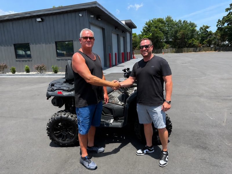 Arthur shaking hands beside his new camo CFMOTO CFORCE 800 ATV