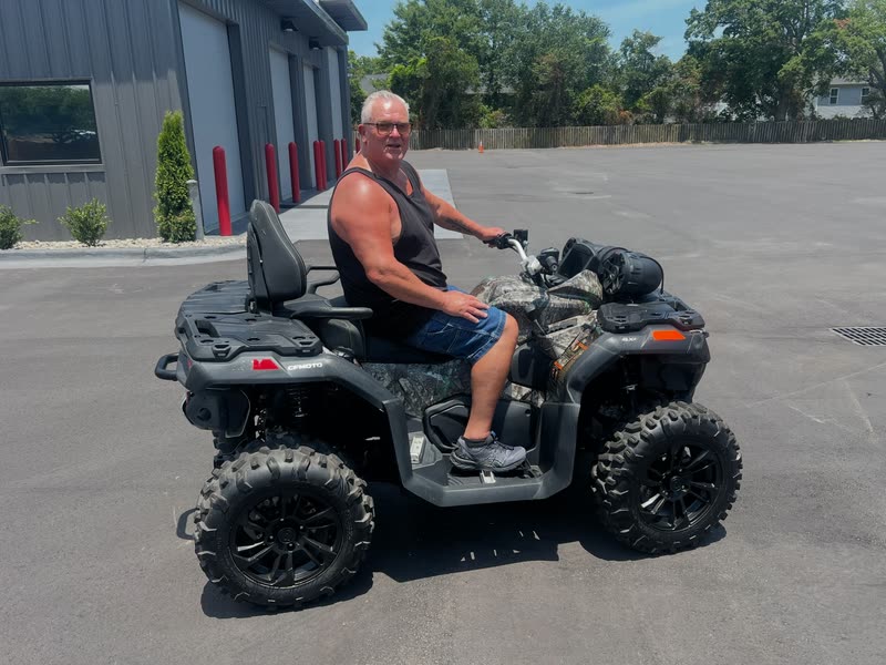 Customer sitting on his new camo CFMOTO ATV