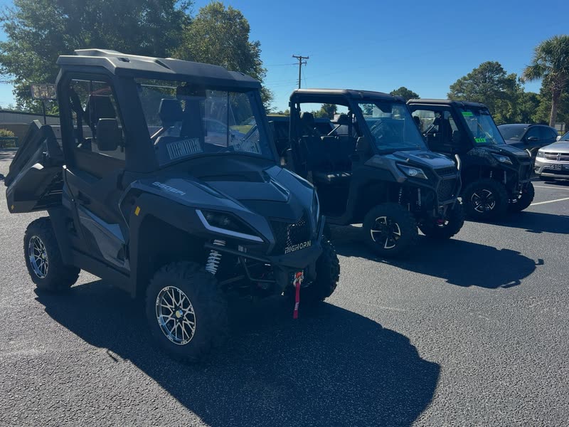 Black Bighorn UTVs with full cabs lined up on the lot