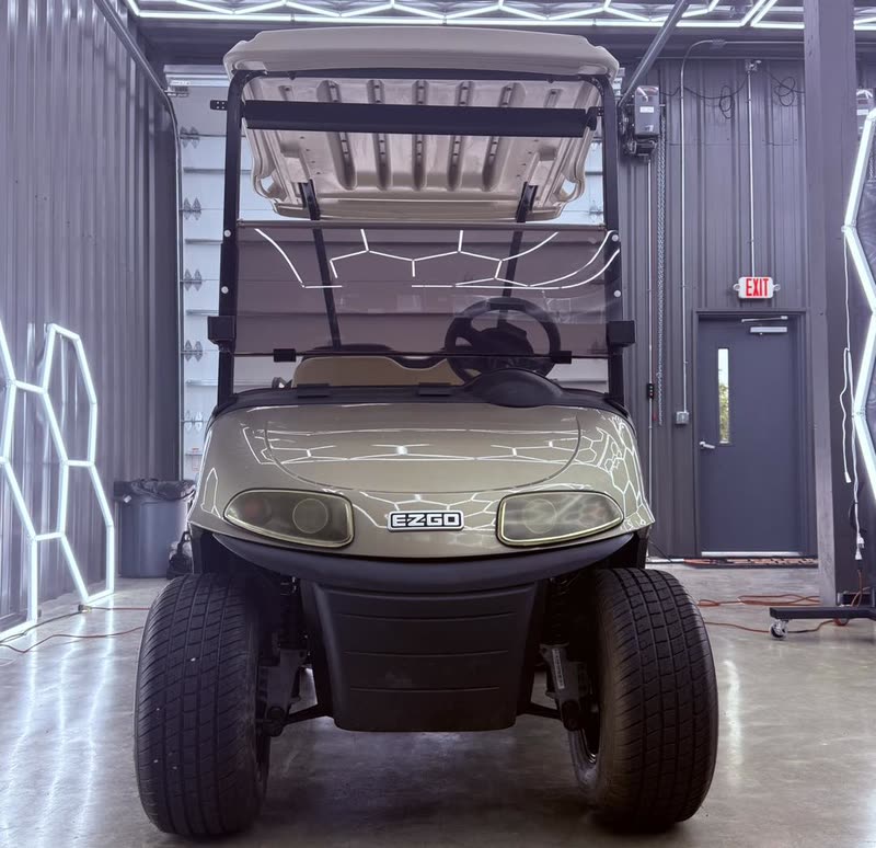 Front view of an E-Z-GO RXV golf cart in the shop