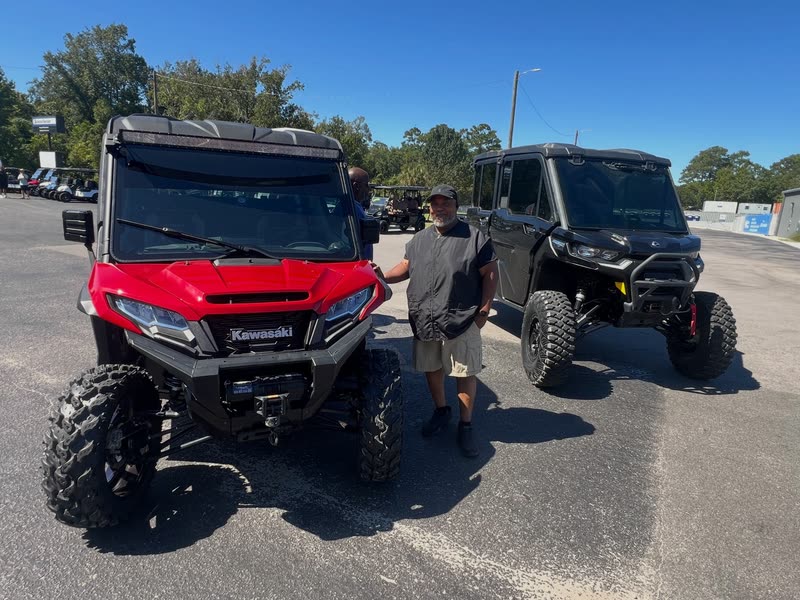 A red and a black full-cab side-by-side on the lot