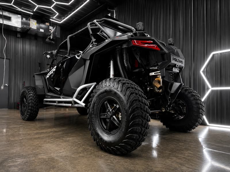 Black Polaris RZR Turbo R 4 from the rear under the hexagon shop lights