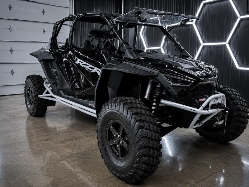 Black Polaris RZR Turbo R 4 from the side in the showroom
