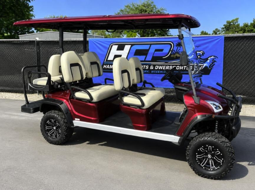 Red Star EV Sirius 6-passenger cart in front of the HCP banner